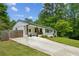 Charming ranch home boasts a white exterior, driveway, landscaping, and inviting front porch at 1477 Spruce Se Dr, Smyrna, GA 30080