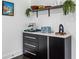 Close up of the kitchen appliances on a black cabinet with a white marble countertop and open shelving at 1477 Spruce Se Dr, Smyrna, GA 30080