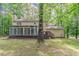 View of back of home with covered porch, wooden deck, and lush green trees at 205 N Fayette Dr, Fayetteville, GA 30214