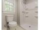 Bathroom featuring a toilet and an all-white shower, complemented by natural light at 205 N Fayette Dr, Fayetteville, GA 30214