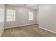 An empty bedroom features two windows, plush carpeting, and neutral wall paint at 205 N Fayette Dr, Fayetteville, GA 30214