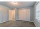 This bedroom has neutral paint, carpeted floors, window blinds, and a closet at 205 N Fayette Dr, Fayetteville, GA 30214
