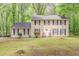 Two story traditional home with light siding and black shutters surrounded by mature trees at 205 N Fayette Dr, Fayetteville, GA 30214
