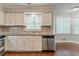 Bright kitchen with white cabinets, granite counters, stainless steel dishwasher and breakfast area at 205 N Fayette Dr, Fayetteville, GA 30214