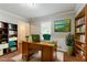 Home office with natural light, wainscoting, built-in bookshelf, and hardwood floors at 205 N Fayette Dr, Fayetteville, GA 30214