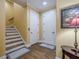 Hallway view with hardwood floors, staircase, and two white panel doors at 2295 Falmouth Se Ct, Smyrna, GA 30080