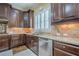 A modern kitchen features stainless steel appliances, granite countertops, and stylish tile backsplash at 2295 Falmouth Se Ct, Smyrna, GA 30080
