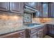 A chef's kitchen shows granite countertops, stainless gas cooktop, custom cabinets and decorative backsplash at 2295 Falmouth Se Ct, Smyrna, GA 30080