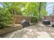Paver patio with a built-in grill, surrounded by lush greenery at 2295 Falmouth Se Ct, Smyrna, GA 30080