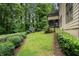 Landscaped backyard featuring a manicured lawn, mature trees, privacy hedges, and a play structure at 3301 Chastain Ridge Dr, Marietta, GA 30066
