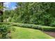 The landscaped backyard has lush grass and clipped hedges offering views to mature shade trees at 3301 Chastain Ridge Dr, Marietta, GA 30066