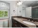 Bathroom featuring double sinks, a large mirror, granite counters, and a doorway into the bedroom at 3301 Chastain Ridge Dr, Marietta, GA 30066