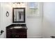 Cozy half-bath featuring a dark wood vanity, granite countertop, traditional fixtures, and bright natural light at 3301 Chastain Ridge Dr, Marietta, GA 30066