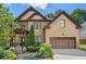 Charming brick home boasts meticulous landscaping, a covered porch, and an attached two-car garage at 3301 Chastain Ridge Dr, Marietta, GA 30066