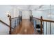 View from the landing to a brightly lit hallway, wooden floors, and decorative wood and iron railings at 3301 Chastain Ridge Dr, Marietta, GA 30066