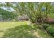 Expansive backyard with lush greenery, stone path, landscaping, and a partial view of the home's exterior at 4135 Creekwood Dr, Cumming, GA 30041