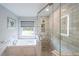 Bathroom showcasing a soaking tub, glass shower, and tiled walls at 4135 Creekwood Dr, Cumming, GA 30041