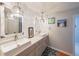 Bright bathroom with double sinks, decorative lighting, and white cabinets at 4135 Creekwood Dr, Cumming, GA 30041
