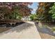 Charming two-story home featuring a welcoming driveway, lush landscaping, and a stone bench at 4135 Creekwood Dr, Cumming, GA 30041