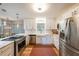Bright kitchen featuring modern stainless steel appliances, white cabinetry, and hardwood floors at 4135 Creekwood Dr, Cumming, GA 30041