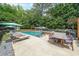 Inviting backyard pool area with lounge chairs, dining table, hot tub, and lush greenery at 4135 Creekwood Dr, Cumming, GA 30041
