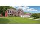 A two-story brick home featuring a lush lawn and an attached two-car garage at 4549 Clarks Creek Ter, Ellenwood, GA 30294