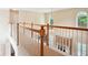 Second story hallway with white railings overlooking a living area with large windows at 4549 Clarks Creek Ter, Ellenwood, GA 30294