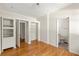 Empty bedroom featuring hardwood floors, built-in shelves, and access to a bathroom at 1290 Mclendon Ne Ave, Atlanta, GA 30307