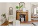 Stylish living room with a decorative fireplace, comfortable chair and ottoman, and a view into the dining area at 1290 Mclendon Ne Ave, Atlanta, GA 30307