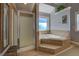 Bathroom featuring a large soaking tub with tiled surround and a glass enclosed shower at 15 Walnut Ridge Way, Covington, GA 30014