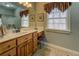 Bathroom featuring a wooden vanity with white countertop, large mirror, and window with natural light at 15 Walnut Ridge Way, Covington, GA 30014