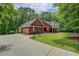 Beautiful brick home with a three-car garage, lush lawn, and mature trees at 15 Walnut Ridge Way, Covington, GA 30014