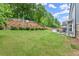 Spacious backyard features a lush lawn, mature trees, and a tiered retaining wall for added privacy at 214 Crestmont Way, Canton, GA 30114