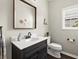 Neutral powder room with a dark wood vanity, white countertop, and modern fixtures at 214 Crestmont Way, Canton, GA 30114