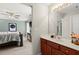 Bathroom with a vanity, large mirror, and a view of a bedroom, seamlessly connecting personal spaces at 214 Crestmont Way, Canton, GA 30114