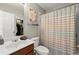 Clean bathroom with a toilet, sink, vanity, and striped shower curtain, providing essential amenities at 214 Crestmont Way, Canton, GA 30114