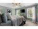 A serene bedroom with natural light, a TV, and calm colors, designed for relaxation and comfort at 214 Crestmont Way, Canton, GA 30114