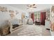 Charming Bedroom adorned with floral wallpaper, complete with a crib and rocking chair for baby's comfort at 214 Crestmont Way, Canton, GA 30114