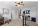 A home office features a standing desk, a ceiling fan, and ample natural light for a comfortable work environment at 214 Crestmont Way, Canton, GA 30114
