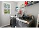 Bright laundry room with modern appliances, shelving and natural light from a window at 214 Crestmont Way, Canton, GA 30114
