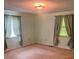 A carpeted bedroom illuminated with two windows and neutral wall color at 4380 Highway 138, Oxford, GA 30054