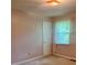 Bedroom featuring a window with sheer curtains, light pink walls, and a white door at 4380 Highway 138, Oxford, GA 30054
