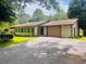 A quaint one-story home featuring a garage, several windows, and a driveway with lush green lawn at 4380 Highway 138, Oxford, GA 30054
