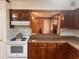 A kitchen with dark wood cabinets, stone-look countertop, and white appliances at 4380 Highway 138, Oxford, GA 30054