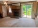 A living room with wood paneling, brick fireplace, and sliding door to a deck at 4380 Highway 138, Oxford, GA 30054