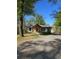 Charming single-story home featuring a covered porch, gravel driveway, and beautiful landscaping at 1016 Green Dr, Canton, GA 30114