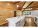 Kitchen island with a farmhouse sink and stainless steel appliances, under a wood-paneled ceiling with exposed beams at 1016 Green Dr, Canton, GA 30114