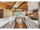 Farmhouse sink with stainless appliances and hardwood floors under a wood-paneled ceiling with exposed beams at 1016 Green Dr, Canton, GA 30114