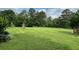 A large backyard bordered by mature trees and landscaping offers plenty of space for relaxation and outdoor activities at 19 Magnolia Ne Ct, Rydal, GA 30171