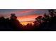 View of a vibrant sunset over a treeline, with an orange and pink sky at 19 Magnolia Ne Ct, Rydal, GA 30171